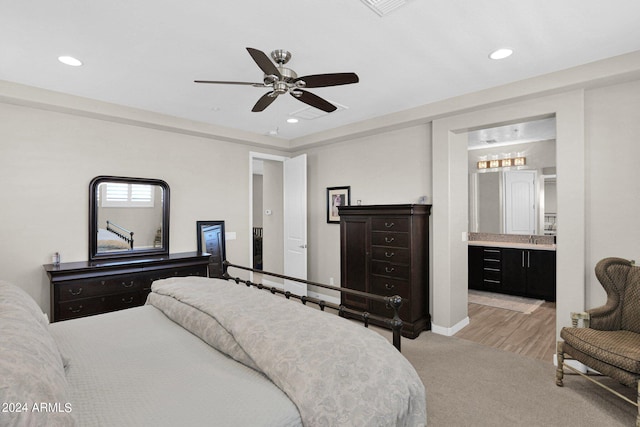 carpeted bedroom featuring sink, ceiling fan, and connected bathroom