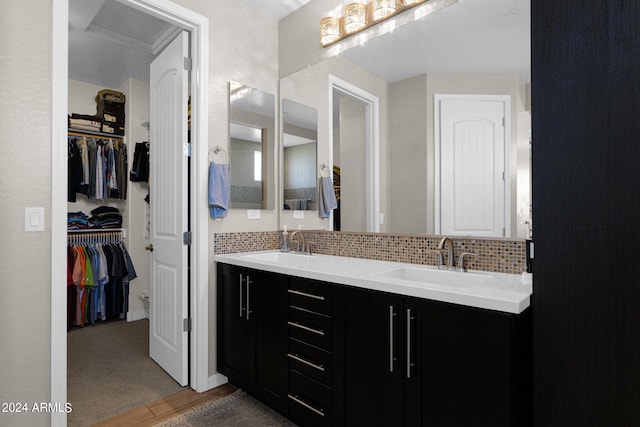 bathroom featuring decorative backsplash, wood-type flooring, and vanity