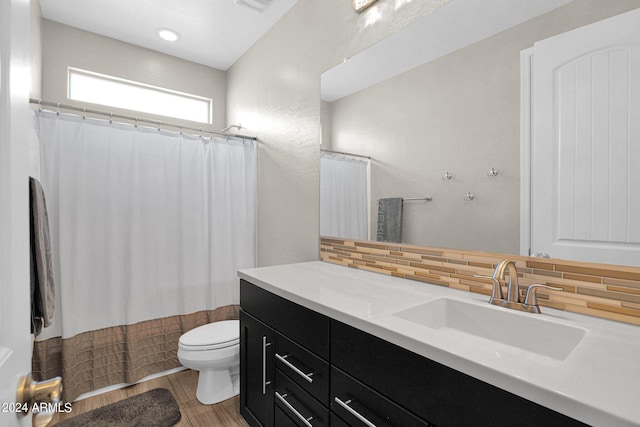 bathroom featuring a shower with curtain, backsplash, vanity, and toilet