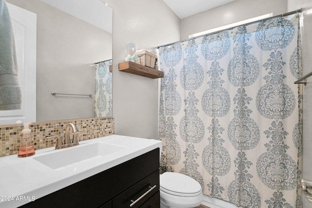 bathroom featuring toilet, walk in shower, vanity, and backsplash