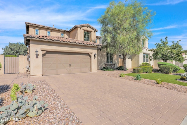 mediterranean / spanish-style house featuring a garage and a front yard