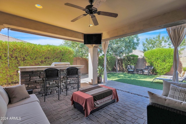 view of patio / terrace featuring ceiling fan, an outdoor hangout area, a bar, and grilling area