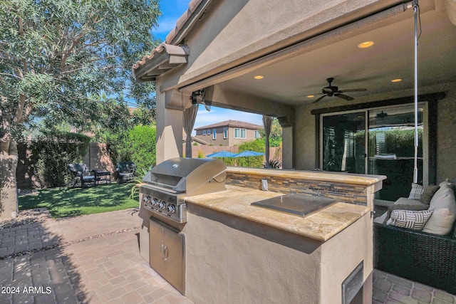 view of patio featuring exterior kitchen, ceiling fan, and area for grilling