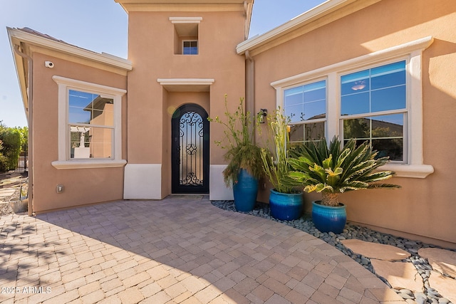 view of exterior entry with a patio area