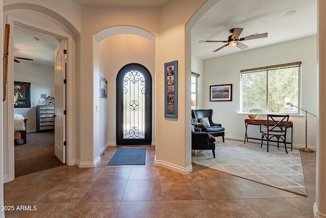 tiled entryway featuring ceiling fan