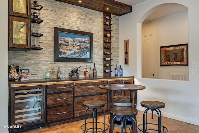 bar featuring beverage cooler and dark brown cabinets