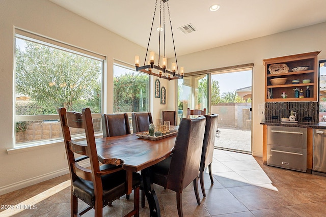 tiled dining room featuring a notable chandelier