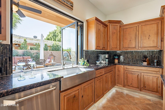 kitchen featuring backsplash, sink, dark stone counters, and dishwasher