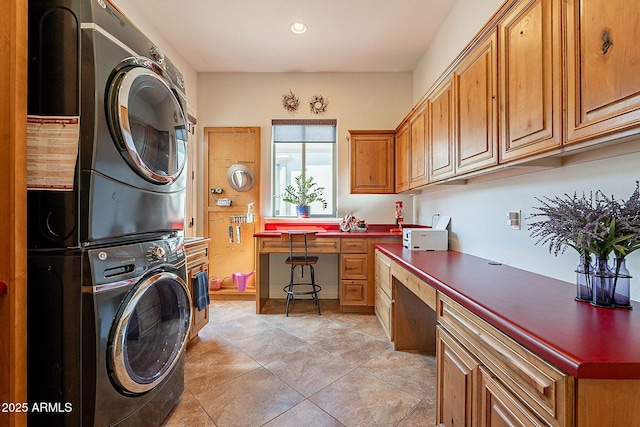 washroom with stacked washer and dryer and cabinets