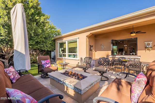 view of patio / terrace featuring ceiling fan and an outdoor fire pit