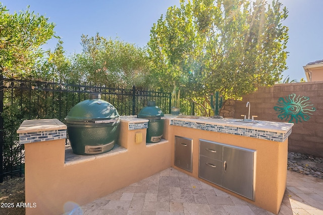 view of patio / terrace featuring area for grilling, sink, and a grill