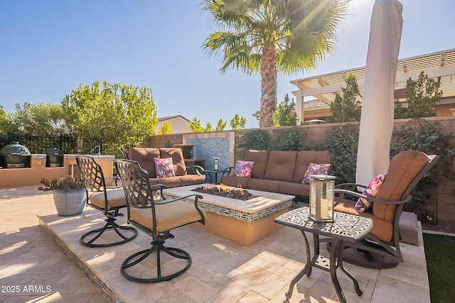 view of patio / terrace with area for grilling, an outdoor living space with a fire pit, and an outdoor kitchen