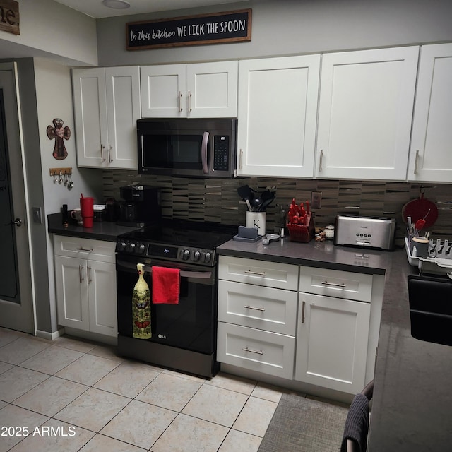 kitchen with light tile patterned flooring, white cabinets, electric range oven, and backsplash