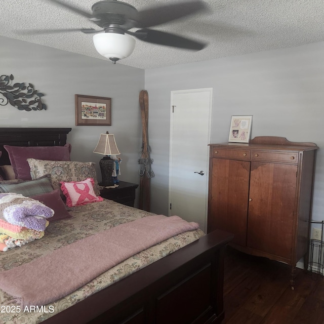 bedroom featuring dark hardwood / wood-style flooring, a textured ceiling, and ceiling fan