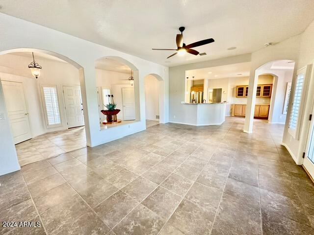 unfurnished living room with ceiling fan