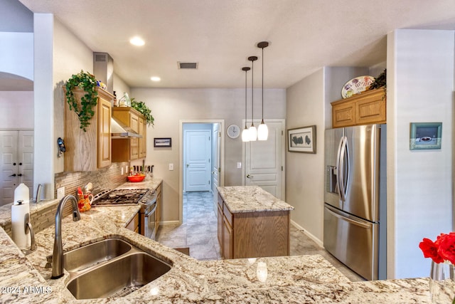 kitchen featuring appliances with stainless steel finishes, tasteful backsplash, sink, a center island, and hanging light fixtures