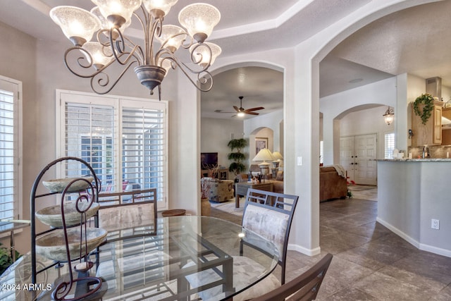 dining room featuring a textured ceiling and ceiling fan with notable chandelier