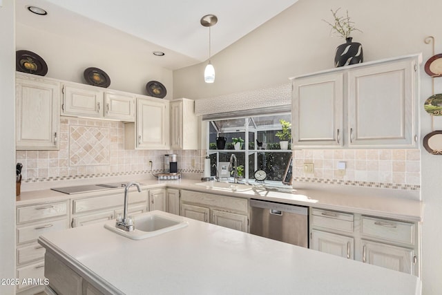 kitchen with vaulted ceiling, light countertops, a sink, and stainless steel dishwasher