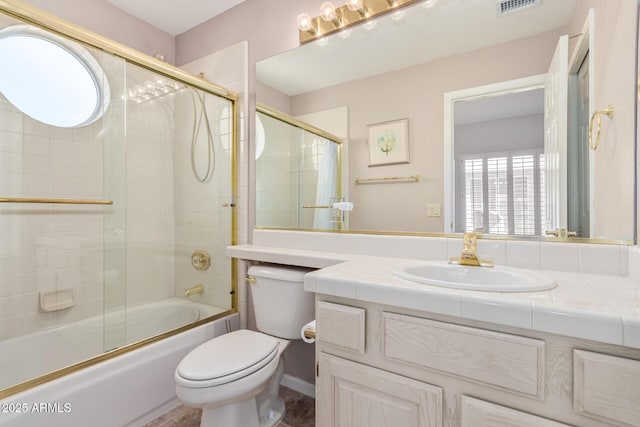 bathroom with enclosed tub / shower combo, visible vents, vanity, and toilet