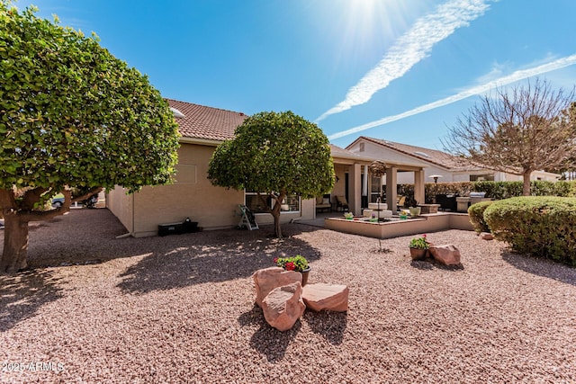 back of property featuring a patio area, a tiled roof, and stucco siding