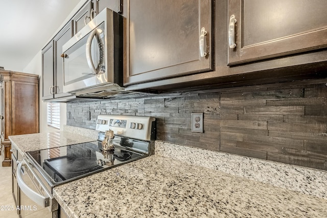 kitchen featuring stainless steel appliances, tasteful backsplash, light stone counters, and dark brown cabinetry