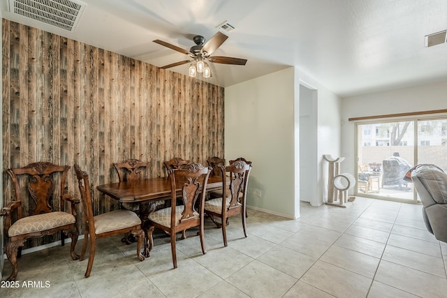 tiled dining area with ceiling fan, wood walls, and visible vents