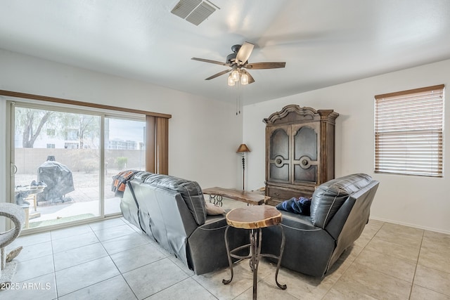 living area featuring ceiling fan, visible vents, baseboards, and light tile patterned flooring