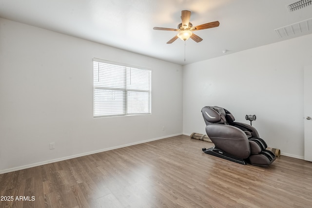 unfurnished room featuring wood finished floors, visible vents, and baseboards