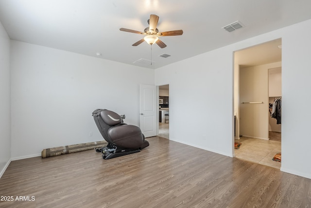 unfurnished room featuring a ceiling fan, visible vents, baseboards, and wood finished floors