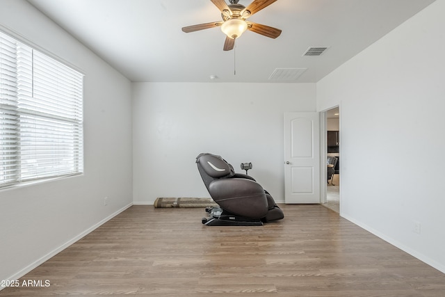 sitting room featuring baseboards, ceiling fan, visible vents, and wood finished floors