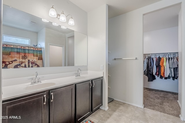 bathroom with double vanity, tile patterned flooring, baseboards, and a sink