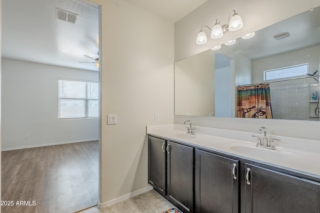 bathroom with double vanity, baseboards, visible vents, and a sink