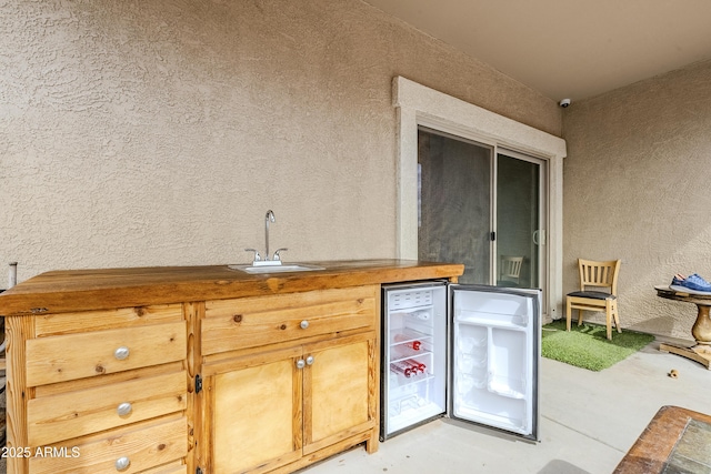 view of patio / terrace with wine cooler, mail area, and a sink