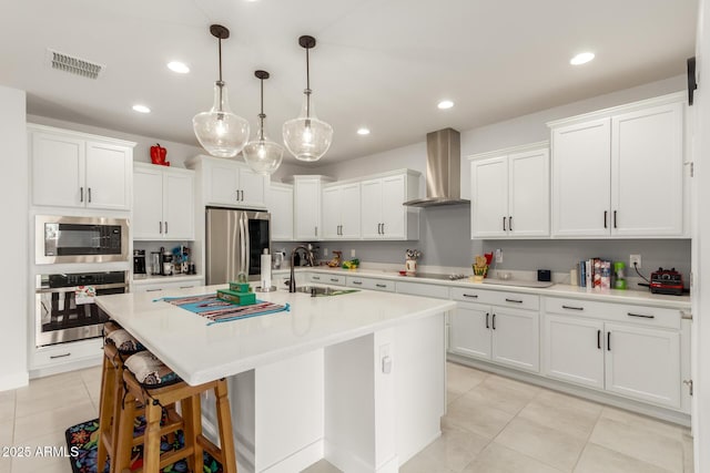 10545 E Texas Ave, Mesa, AZ 85212 - kitchen featuring stainless steel appliances, wall chimney exhaust hood, a sink, light tile patterned floors, and light countertops