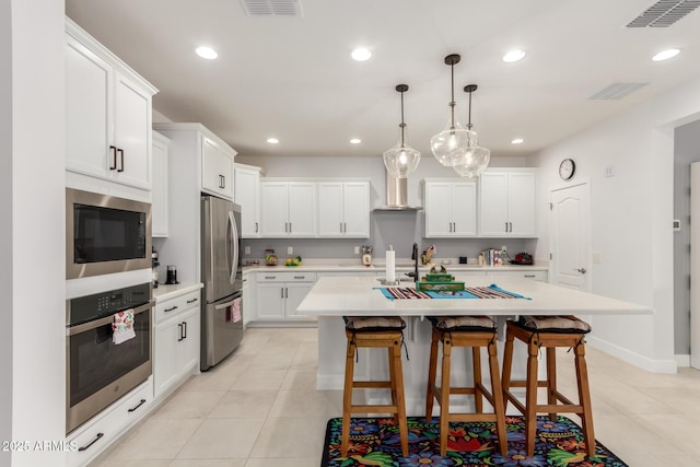 10545 E Texas Ave, Mesa, AZ 85212 - kitchen with stainless steel appliances, light countertops, light tile patterned flooring, a kitchen breakfast bar, and recessed lighting