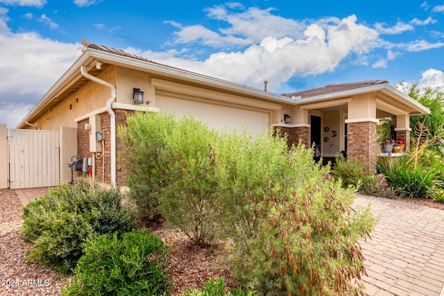 10545 E Texas Ave, Mesa, AZ 85212 - view of front of property featuring stucco siding, a gate, decorative driveway, and a garage