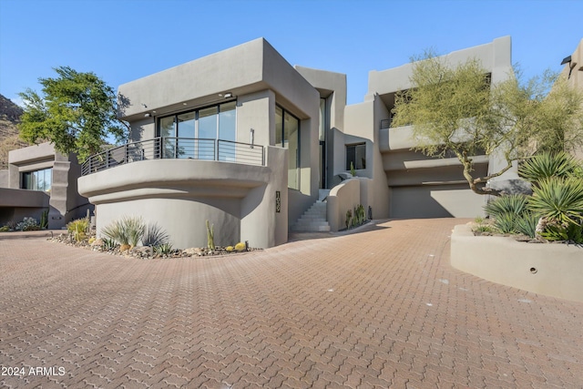 view of front facade featuring a garage and a balcony