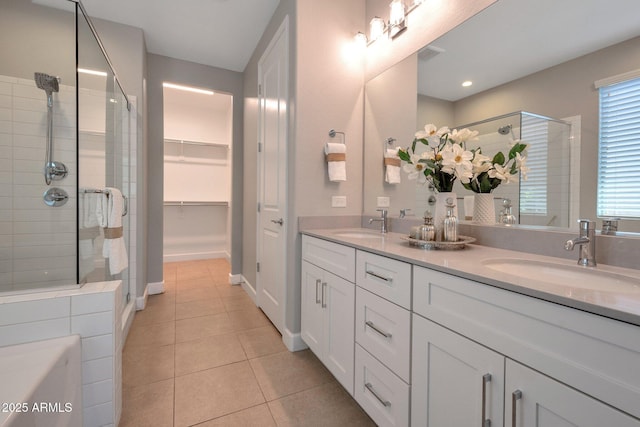16935 W Sheridan St, Goodyear, AZ 85395 - full bathroom featuring a stall shower, tile patterned flooring, double vanity, a walk in closet, and baseboards