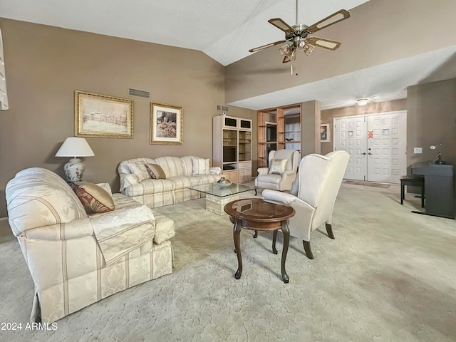 carpeted living room with ceiling fan, a textured ceiling, and vaulted ceiling