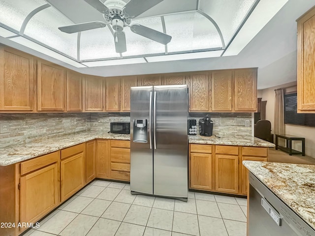 kitchen with backsplash, ceiling fan, stainless steel fridge, light stone countertops, and light tile patterned floors