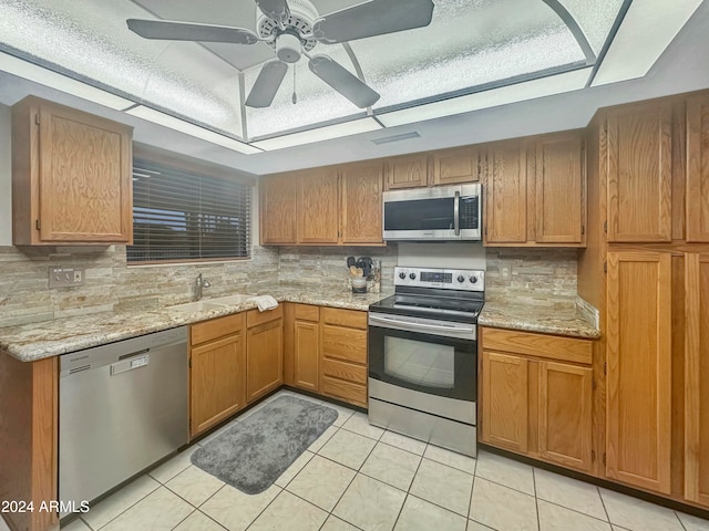 kitchen featuring ceiling fan, sink, stainless steel appliances, tasteful backsplash, and light tile patterned floors