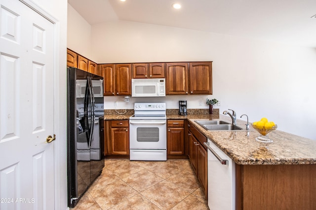 kitchen with stone counters, sink, vaulted ceiling, white appliances, and light tile patterned floors