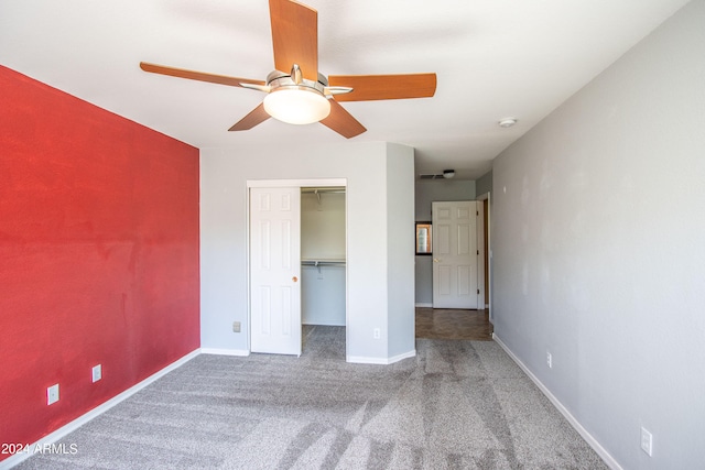 unfurnished bedroom featuring carpet, ceiling fan, a walk in closet, and a closet