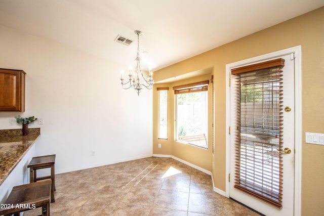 dining area featuring light tile patterned floors and an inviting chandelier