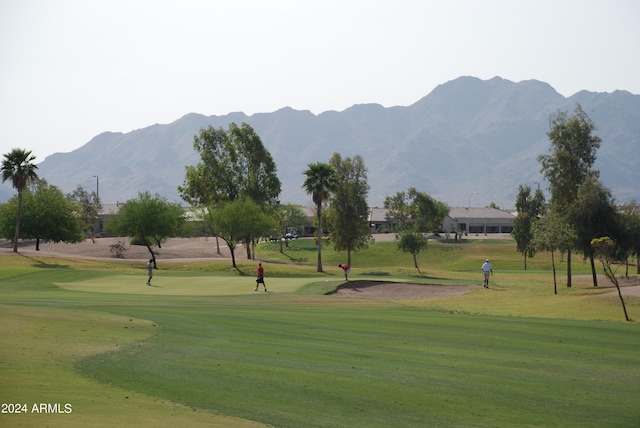 view of home's community with a mountain view and a yard