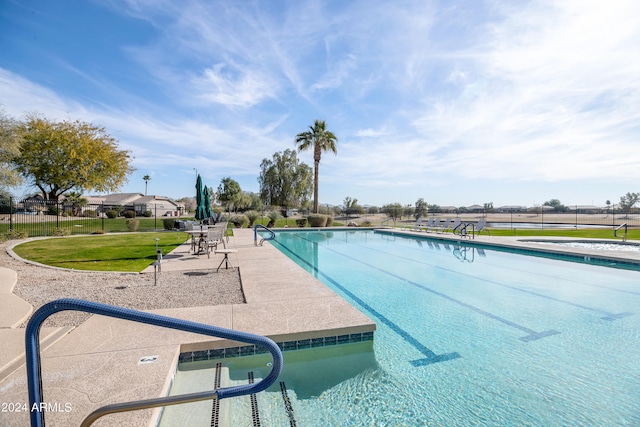 view of swimming pool with a patio area and a yard