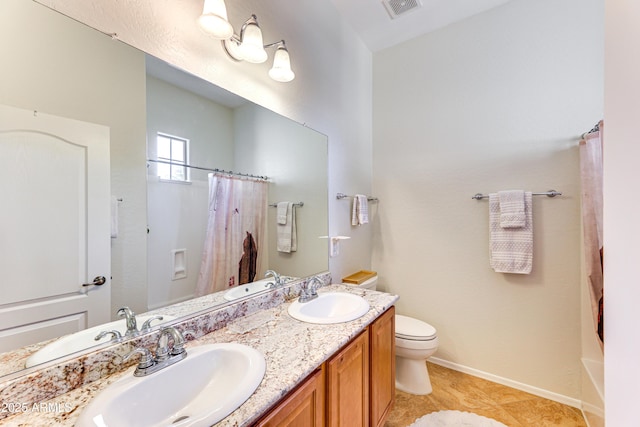 bathroom featuring tile patterned flooring, vanity, and toilet