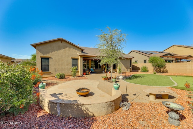 back of property with a patio and an outdoor fire pit