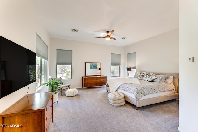 bedroom with multiple windows, light colored carpet, and ceiling fan