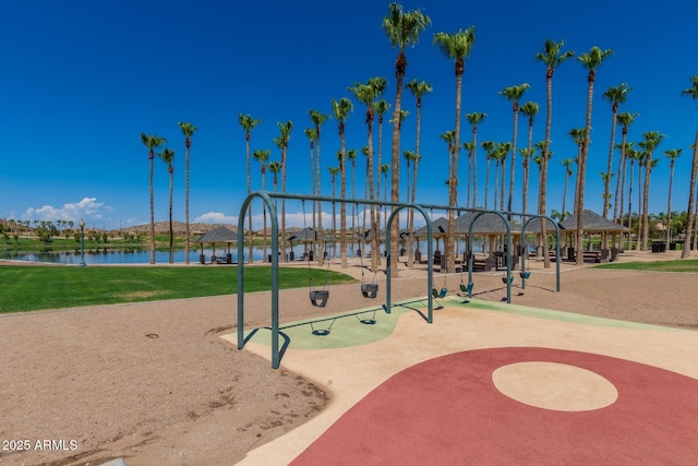 view of property's community featuring a lawn, a playground, and a water view